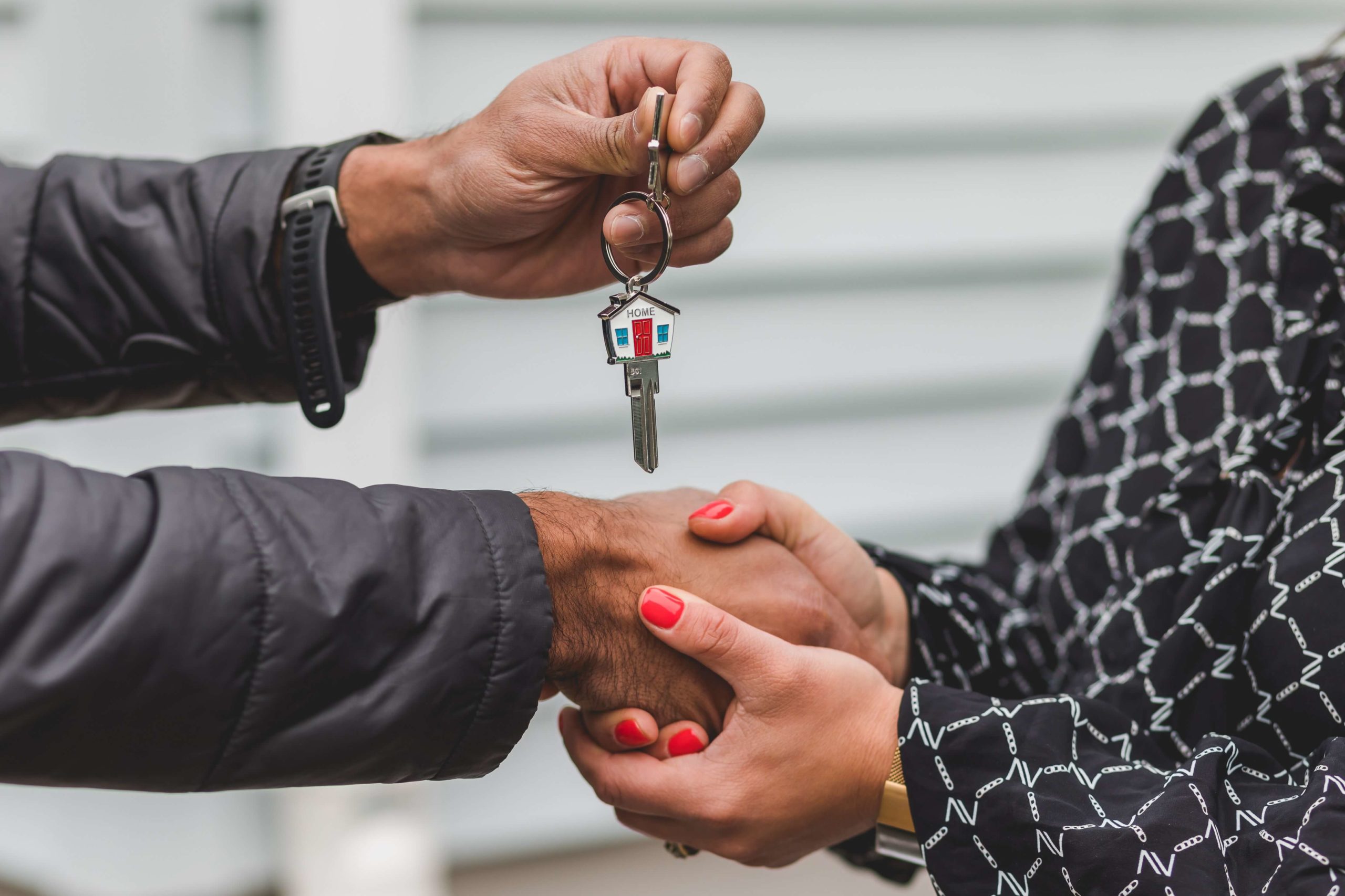 Landlord shaking tenant's hand and handing over key